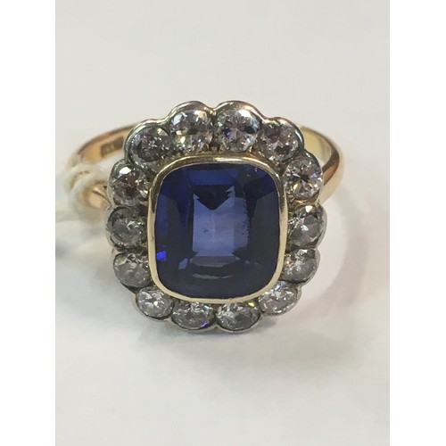 100C - 18ct gold sapphire blue stone and diamond ring, the blue stone approximately 10mm x 8mm encircled by... 