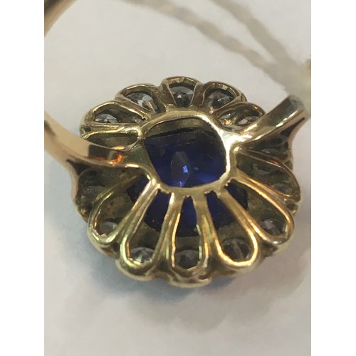 100C - 18ct gold sapphire blue stone and diamond ring, the blue stone approximately 10mm x 8mm encircled by... 