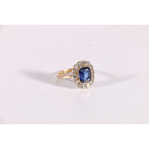 100C - 18ct gold sapphire blue stone and diamond ring, the blue stone approximately 10mm x 8mm encircled by... 