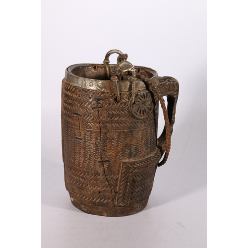 424 - Nepalese carved wooden pail with metal band to the rim, base and handles and twisted carrying ropes,... 