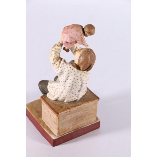 269 - Russian Gardner style bisque porcelain figure of seated man holding baby aloft, red back stamp 