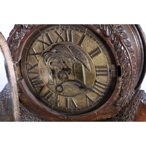 304 - An unusual carved mahogany death clock, the brass dial with gravestone supported by eagle, skull and... 