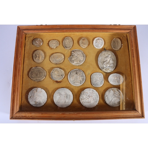 318 - Grand Tour, a case of nineteen Romanesque intaglio plaster impression roundels, the largest 8cm x 6.... 