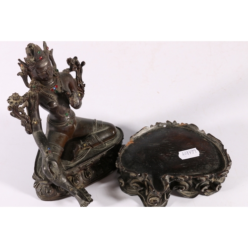 345 - A 19th century Indian bronze Tara seated on a double lotus throne, with inset glass 'jewels', carved... 