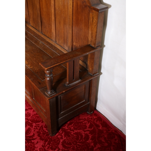 432 - Antique oak settle with high panel back above hinged bench seat, raised on bun supports, 126cm tall ... 