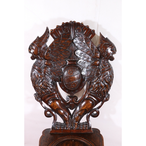 433 - Gothic revival heavily carved oak panel back hall chair raised on hoof supports with lion head to sk... 