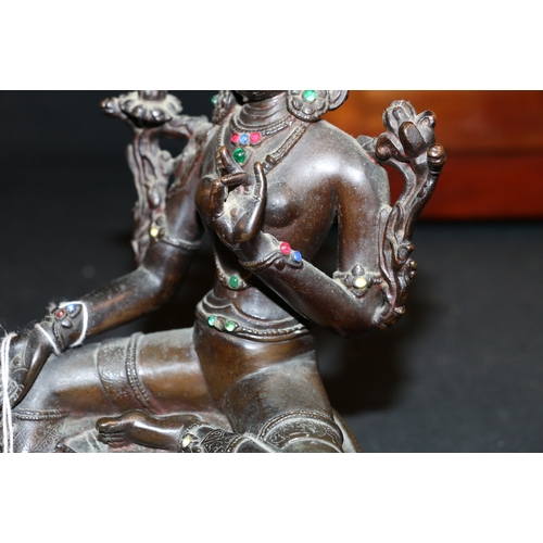 345 - A 19th century Indian bronze Tara seated on a double lotus throne, with inset glass 'jewels', carved... 