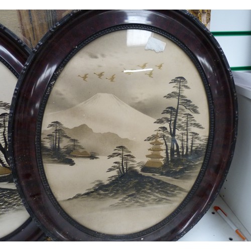 154 - Pair of oval Japanese pictures of Mount Fuji, heightened with gilt.