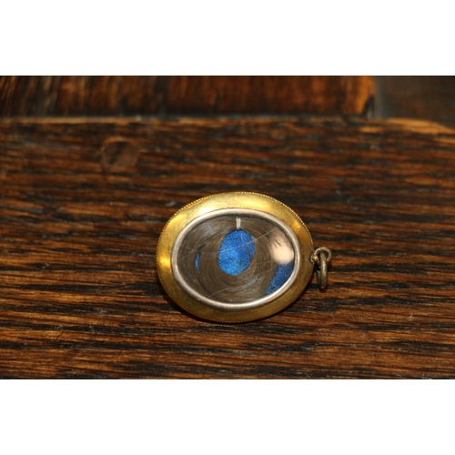 126 - Victorian unhallmarked yellow metal mourning pendant of oval from with blue enamelled cabochon to th... 