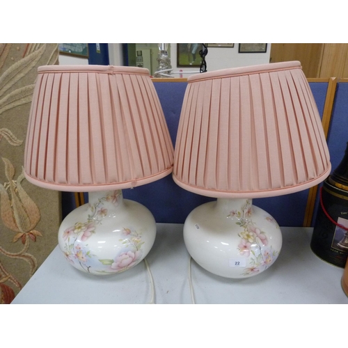 22 - Two white porcelain table lamps with floral decoration.