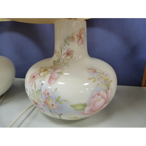 22 - Two white porcelain table lamps with floral decoration.