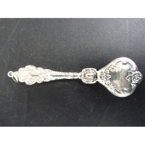 298 - Silver baby rattle with floral repousse decoration.