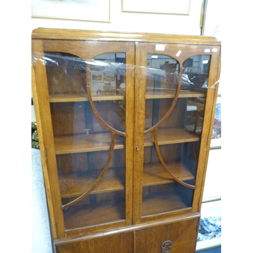 445 - Oak glazed bookcase with cupboards below.