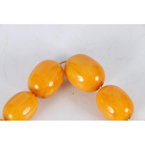 150A - Large strand of graduated butterscotch amber style beads, the largest bead approximately 27mm x 22mm... 