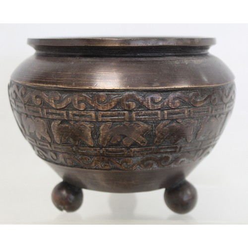 233 - Eastern bronze pot of squat circular form with band of archaic decoration on three ball feet, 12cm h... 