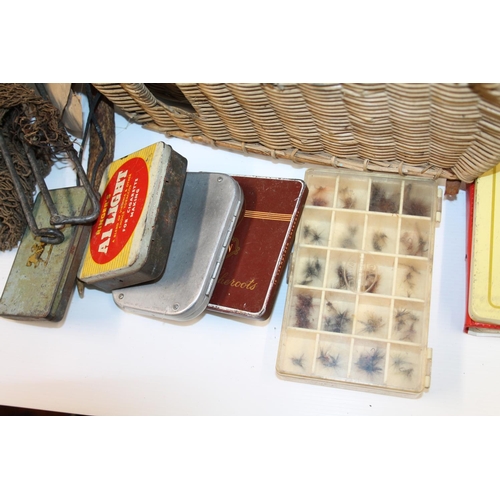 135 - Wicker fishing basket containing fishing tackle, tins, etc. and a canvas satchel containing fishing ... 