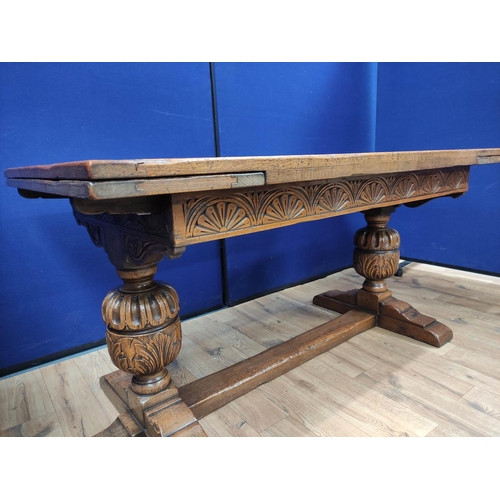 616 - Oak refectory draw leaf dining table, the draw leaf plank top above a carved frieze, raised on carve... 