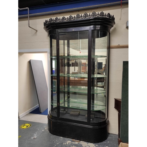 623 - Antique ebonised shop cabinet, with gothic style trellis pediment above a glazed door enclosing glas... 