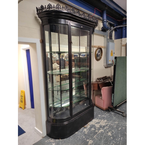 623 - Antique ebonised shop cabinet, with gothic style trellis pediment above a glazed door enclosing glas... 