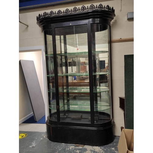 623 - Antique ebonised shop cabinet, with gothic style trellis pediment above a glazed door enclosing glas... 