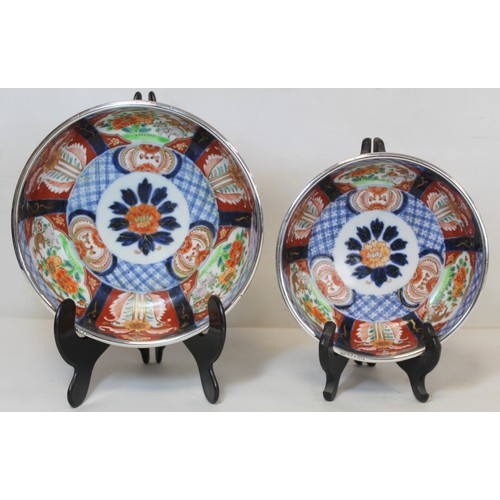 252 - Graduated pair of Japanese Imari bowls with panels of flowers and mythical creatures and silver rims... 