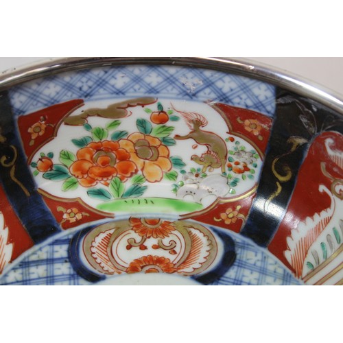 252 - Graduated pair of Japanese Imari bowls with panels of flowers and mythical creatures and silver rims... 