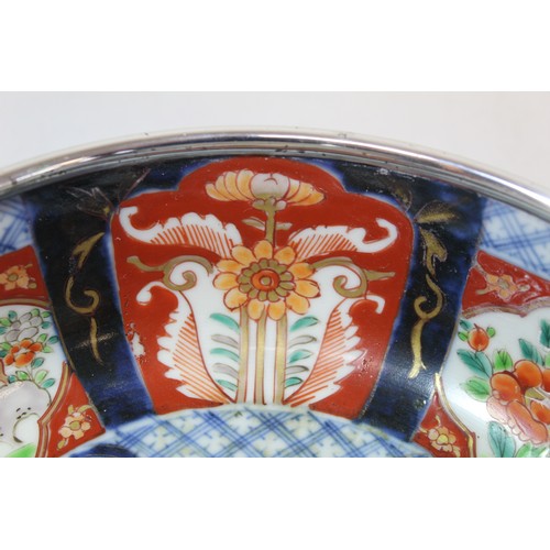 252 - Graduated pair of Japanese Imari bowls with panels of flowers and mythical creatures and silver rims... 