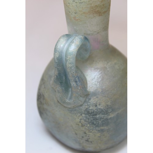 261 - Antique glass flask or ewer, possibly Roman, the flattened globular base with tall flared neck, fold... 