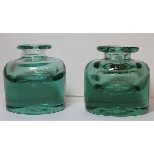 262 - Two 19th century heavy green glass inkwells of cylindrical form with sloping shoulders, short neck a... 