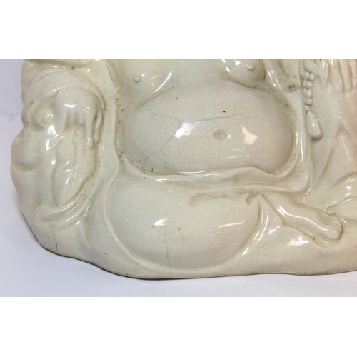 267 - Oriental white glazed pottery figure of Buddha or Hotei, seated and smiling, 17cm high.