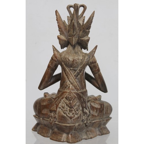 275 - Eastern carved hardwood figure of a Buddha seated on a triangular lotus throne, 28cm high, signed wi... 