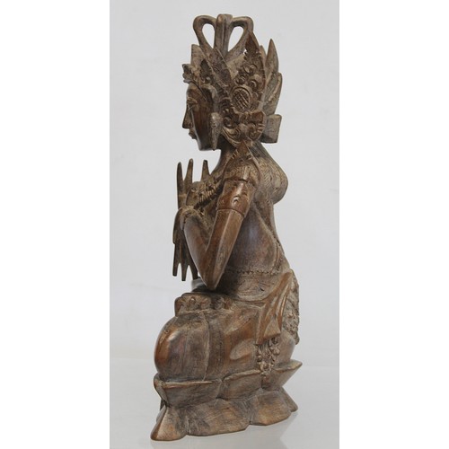 275 - Eastern carved hardwood figure of a Buddha seated on a triangular lotus throne, 28cm high, signed wi... 