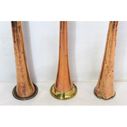 282 - Three copper coach horns, with brass and white metal mounts, 122cm, 101cm and 98cm.  (3).