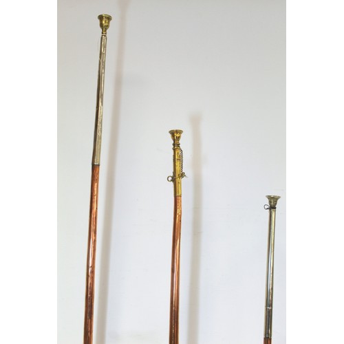 282 - Three copper coach horns, with brass and white metal mounts, 122cm, 101cm and 98cm.  (3).