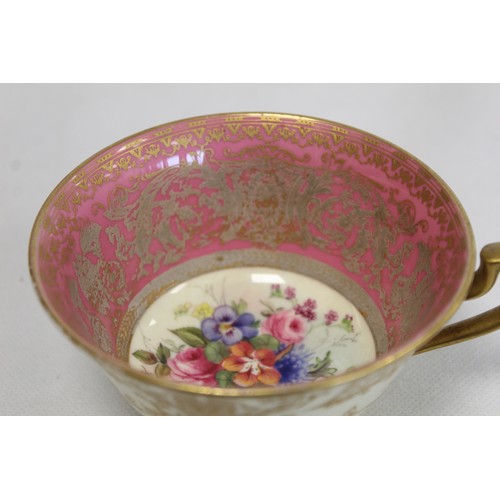 304 - Royal Worcester cabinet cup and saucer with polychrome painted floral panels surrounded by pink and ... 