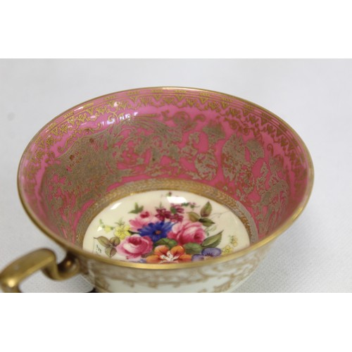 304 - Royal Worcester cabinet cup and saucer with polychrome painted floral panels surrounded by pink and ... 