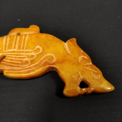 185 - Red-brown Chinese jade carving of a curved mythical animal, 11cm long.