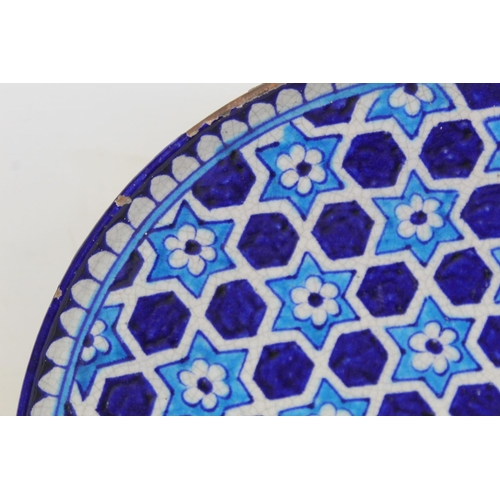 327 - Iznik pottery circular plate with flowerhead star lattice decoration in turquoise and royal blue, 32... 