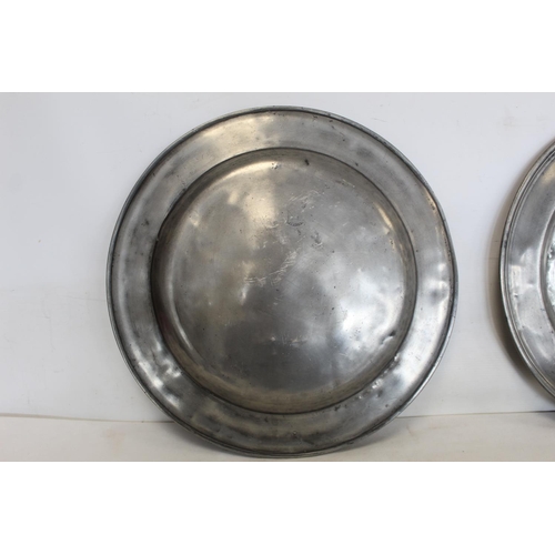 335 - Two large circular pewter chargers, each 42cm diam., with stamped initials M.R.D. (one split); a pew... 