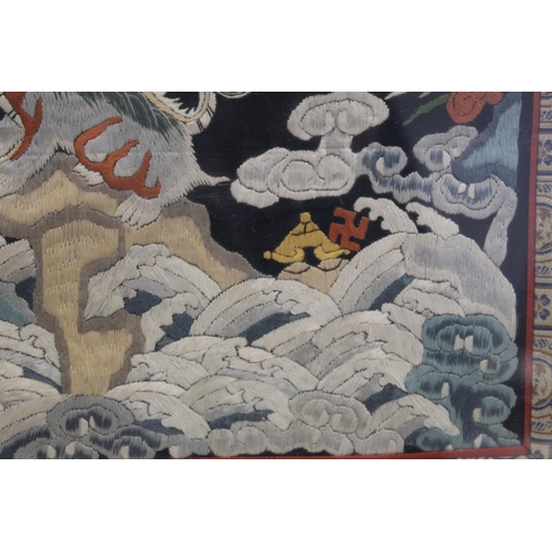 452 - 19th or early 20th century Chinese embroidered silk panel depicting a Dog of Fo on rock amongst foam... 