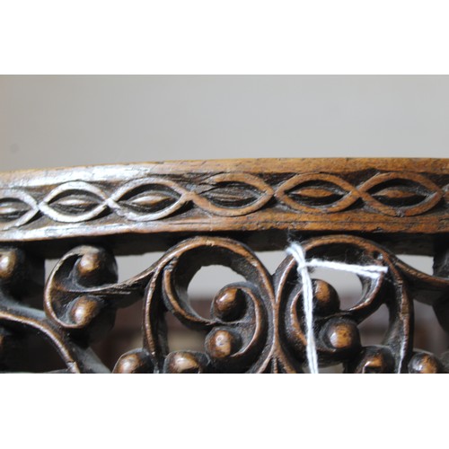 271 - Eastern pierced and carved hardwood footstool of oval form with four scroll feet and foliate decorat... 