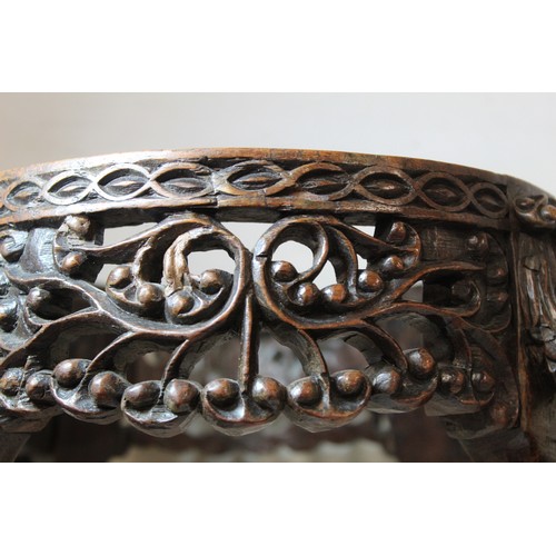 271 - Eastern pierced and carved hardwood footstool of oval form with four scroll feet and foliate decorat... 