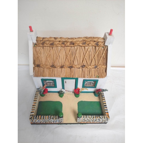 45 - Vintage wooden painted model cottage with white walls and rush roof. H26cm