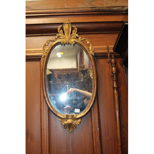 826 - Gilt framed floral encrusted oval wall mirror, 74 x 36cm.