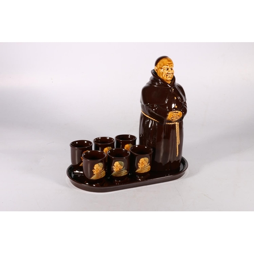 144 - Monk decanter and six matching drinking cups on serving tray.