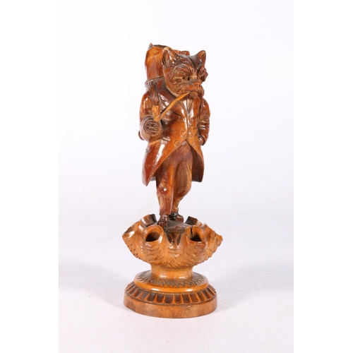 67 - Carved treen Black Forest style smoker's stand with dog smoking a pipe support, 18cm tall.