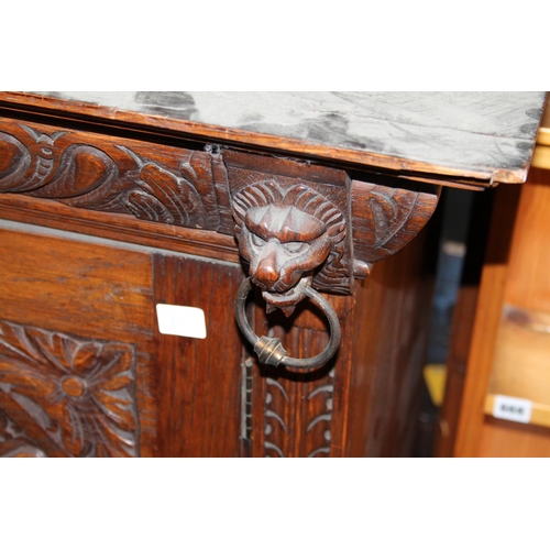 715 - Heavily carved oak single drawer wardrobe, with lion head to the cornice and carved central panel.