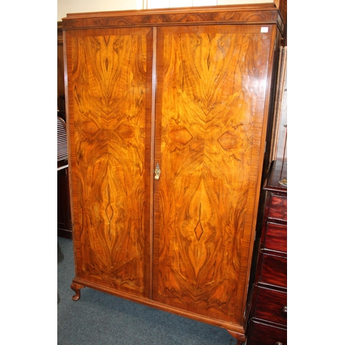 717 - Walnut two door wardrobe, raised on cabriole supports.