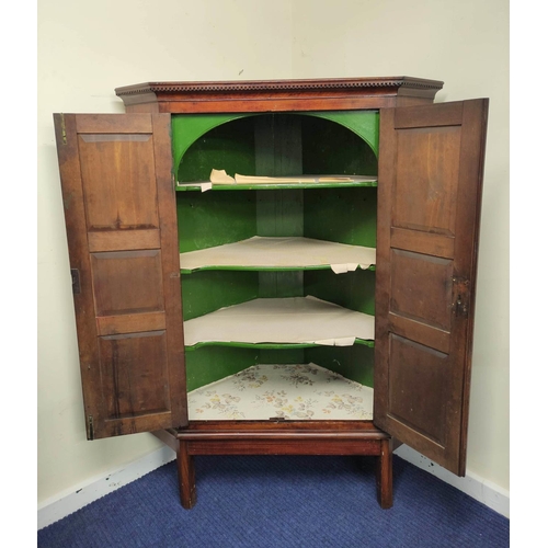 543 - 19th century mahogany corner cupboard with two panelled doors enclosing a shelved interior, on a fix... 