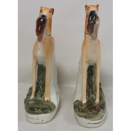 195 - Pair of Staffordshire Pottery figures of greyhounds, each standing on naturalistic oval plinth base,... 